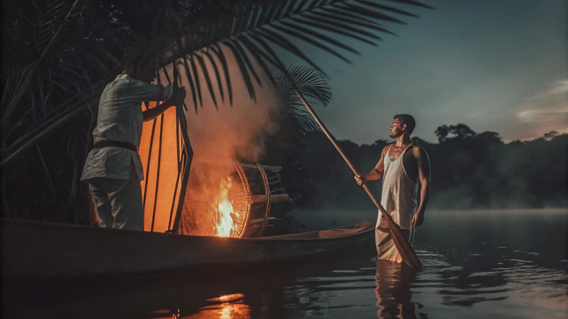 A canoe at dusk on a misty Amazon river, the warm glow of a cooking fire on board as a traveller paddles toward a remote community