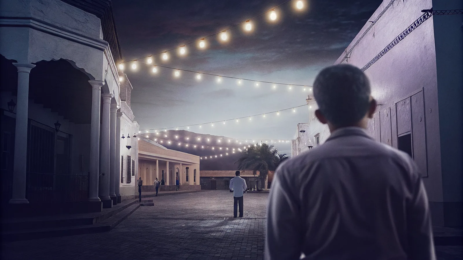 An El Salvador town plaza at dusk under string lights